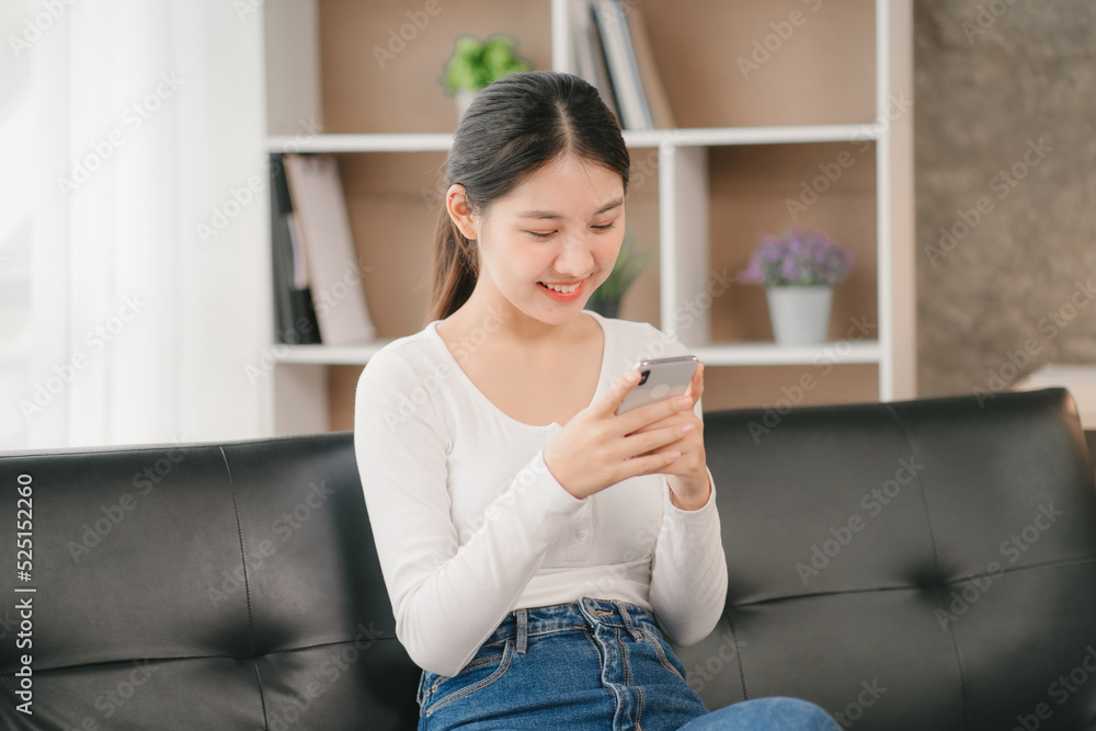 Asian woman happy holding laptop phone sitting sofa smiling good mood indoors indoors Asian woman happy holding laptop phone sitting sofa smiling good mood indoors indoors