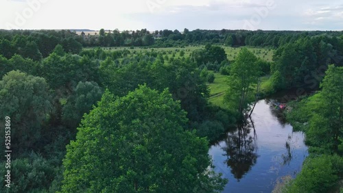 Aerial view of camping with kayaks on the beach of river on a sunny day. Nature background. Active rest concepts. Modern kayaks with paddles on beach near river. Summer camp activity.