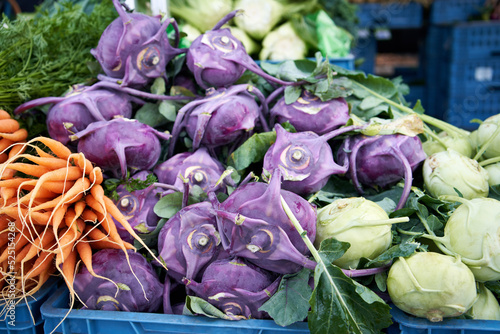 Fresh purple and green kohlrabis and carrots at the farmers' market photo