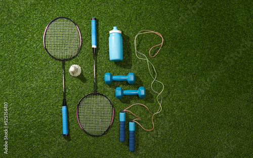 Set of different sports equipment on green grass background. Flat lay.