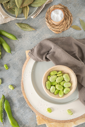 Fresh and raw green broad beans on kitchen table. photo