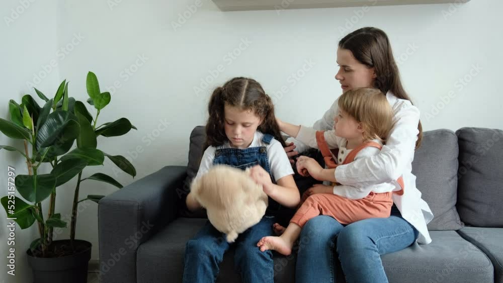 Happy loving young mother brushing beautiful small daughters hair sit on cozy sofa in living room at home. Cute little girls getting ready in morning loving mom enjoying parenthood caring for childs Happy loving young mother brushing beautiful small daughters hair sit on cozy sofa in living room at home. Cute little girls getting ready in morning loving mom enjoying parenthood caring for childs