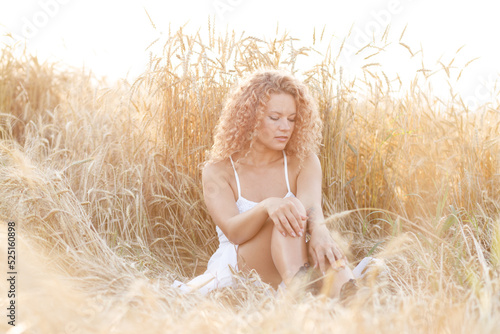 curly-haired girl in a field at sunset