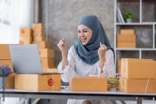 Muslim Young Asian business woman startup sme small business entrepreneur SME distribution warehouse with parcel mail box. Muslim girl SME Online marketing and product packaging and delivery service.