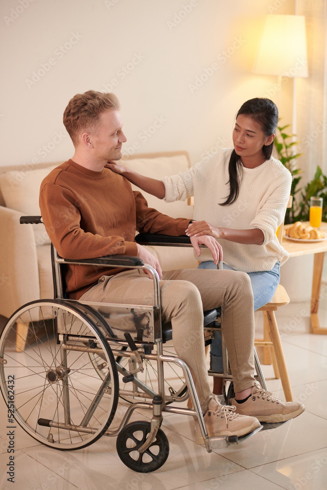 Girlfriend Supporting Young Man in Wheelchair Girlfriend Supporting Young Man in Wheelchair
