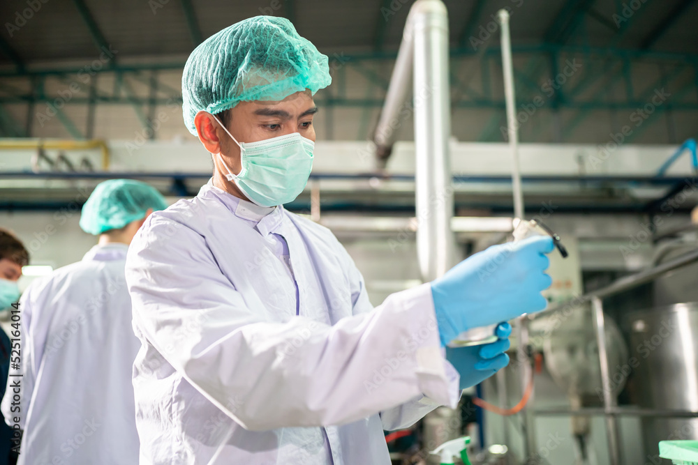 Engineer working at Fruit juice Bottle Automated conveyor belt production system. Business and Technology for Food and beverage industry. Engineer working at Fruit juice Bottle Automated conveyor belt production system. Business and Technology for Food and beverage industry.