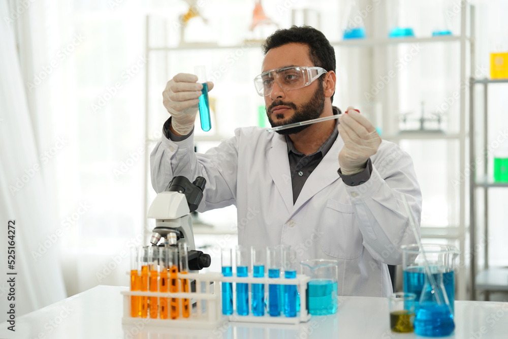 Fototapeta premium scientist doing research on plants holding a green solution in a test tube