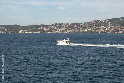 View of a yacht passing on Bosphorus in Istanbul. It is a sunny summer day. Beautiful travel scene.