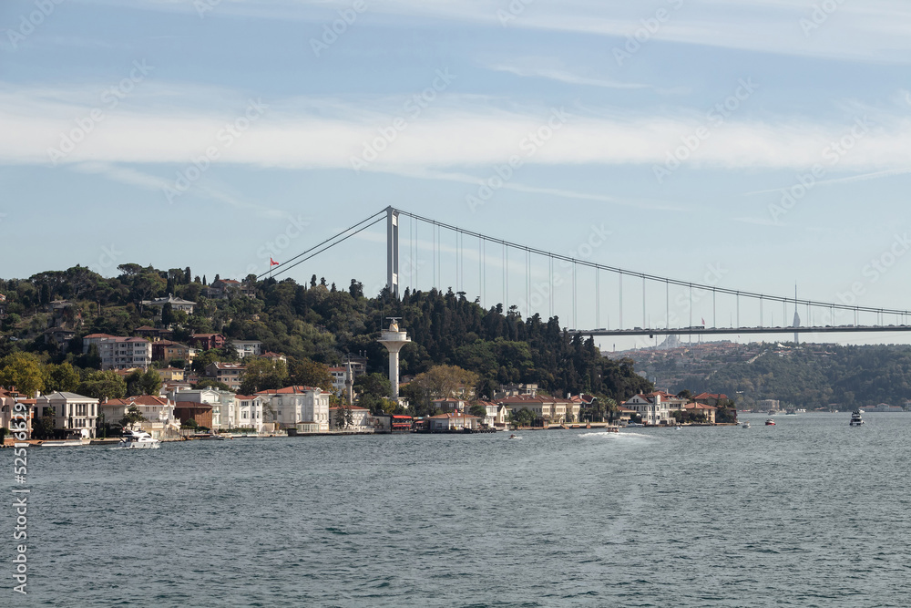 Naklejka premium View of boats passing on Bosphorus, Kanlica neighborhood and FSM bridge in Istanbul. It is a sunny summer day. Beautiful travel scene.