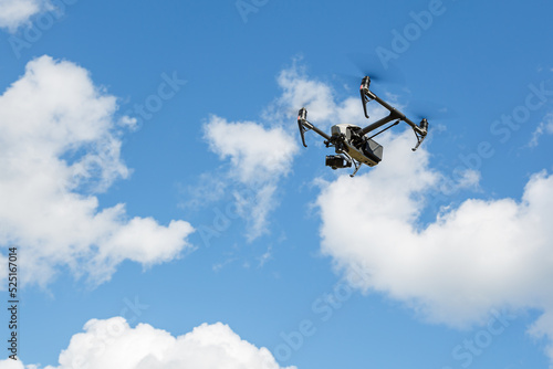 Fototapeta Naklejka Na Ścianę i Meble -  an unmanned quadcopter with a digital camera on a blue sky background.