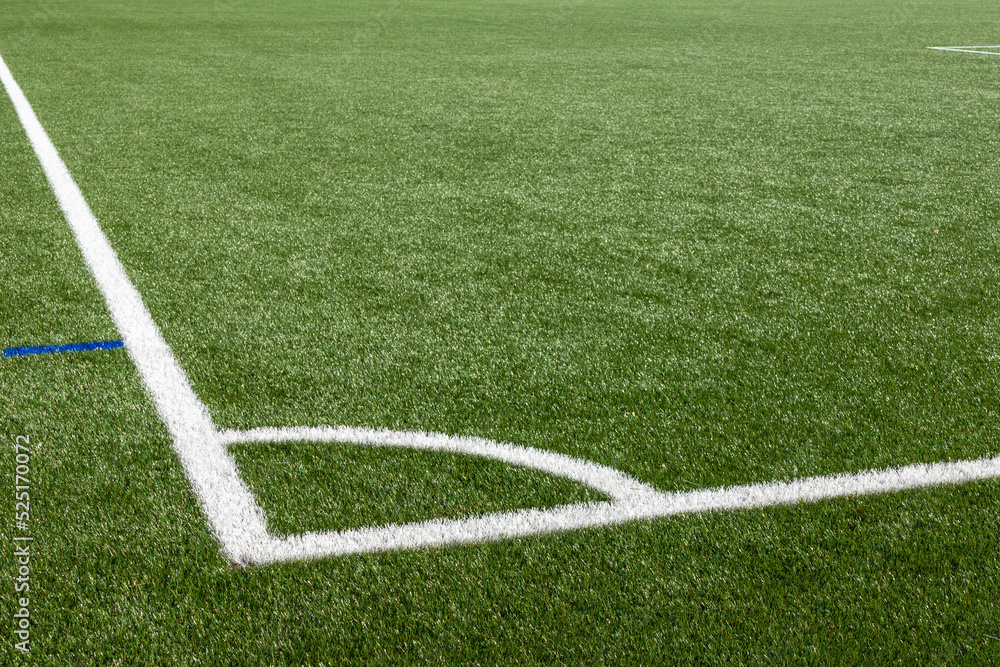 Football field with artificial turf and white markings, detail  .