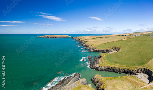 Aerial view of a tiny sandy beach surrounded by cliffs on the coast of Wales (Gwbert, Pembrokeshire)
