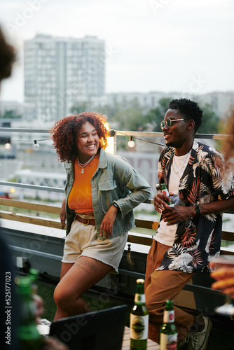 Foto Happy young black couple in stylish casualwear chatting at party while standing