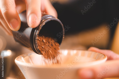 barista holding hand grinde...