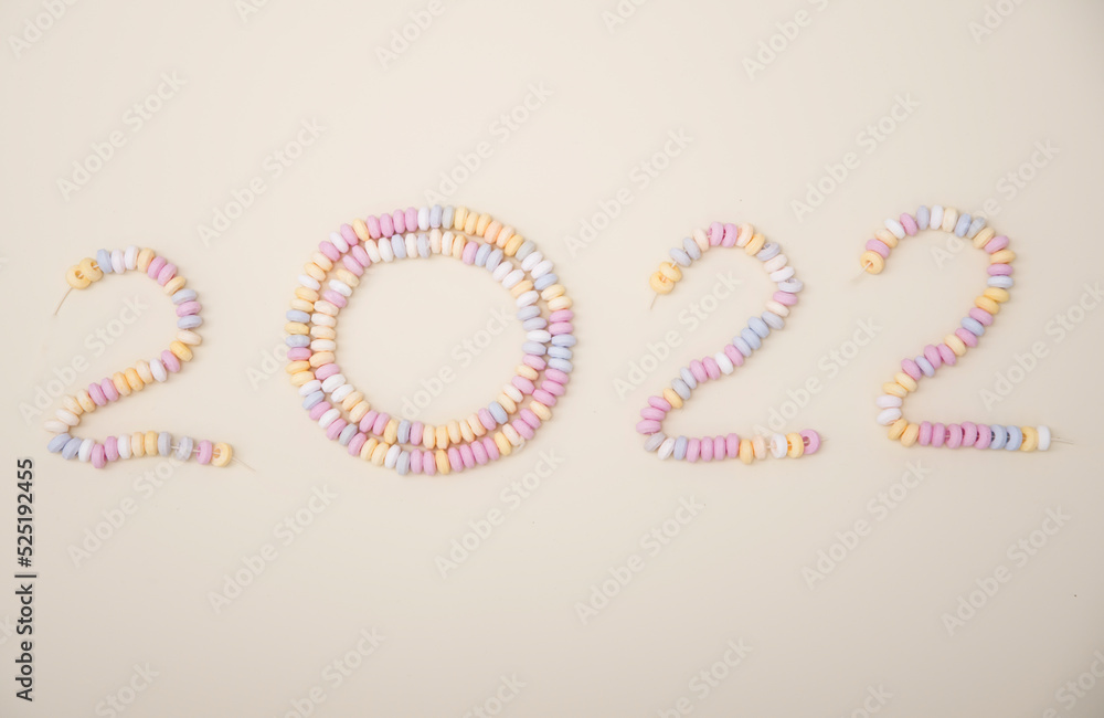 Obraz premium figures of the year 2022 lined with pastel colors candies lettering