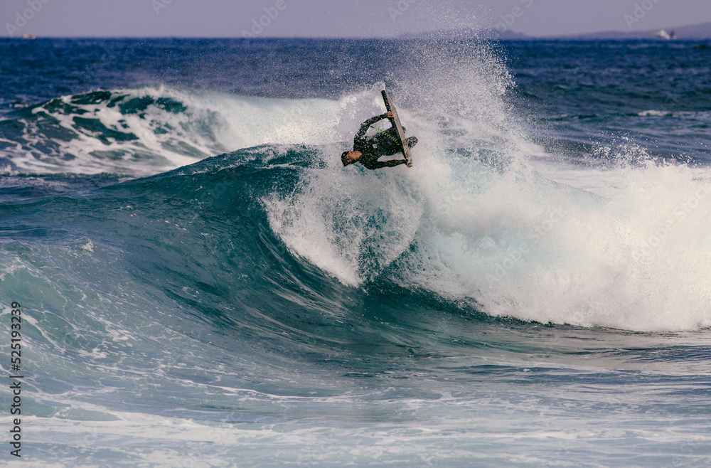 PUERTO DE SANTIAGO, TENERIFE - JUNE 2022: surfer riding the waves in Tenerife PUERTO DE SANTIAGO, TENERIFE - JUNE 2022: surfer riding the waves in Tenerife
