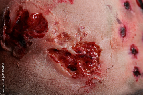 Forehead of undead evil zombie in studio, showing bloody scars and wounded face on camera. Dangerous cruel monster having dirty wounds and creepy scratches with blood. Close up.