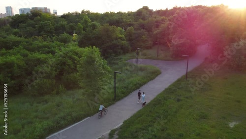 Aerial flying above recreation park lanes at sunset, green summer Kharkiv city park Sarzhyn Yar. Botanical garden in residential area in sunlight photo