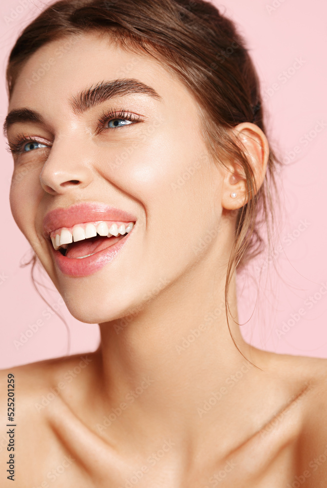 Skin care. Woman with beauty face touching healthy facial skin portrait. Beautiful smiling girl model with natural makeup touching glowing hydrated skin on pink background closeup Skin care. Woman with beauty face touching healthy facial skin portrait. Beautiful smiling girl model with natural makeup touching glowing hydrated skin on pink background closeup