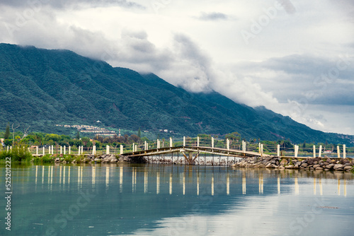 bridge over a calm lake with green panorama