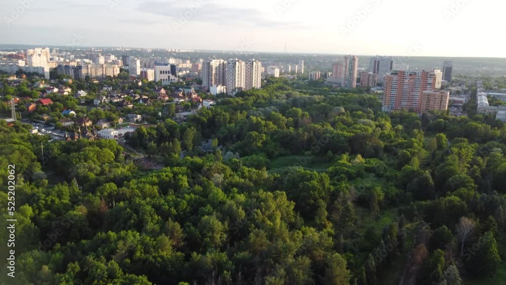 Aerial sunset flying forward view on green summer Kharkiv city and popular recreation park Sarzhyn Yar. Botanical garden in residential area in sunlight Aerial sunset flying forward view on green summer Kharkiv city and popular recreation park Sarzhyn Yar. Botanical garden in residential area in sunlight