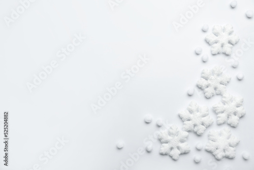 Beautiful snowflakes and decorative balls on white background, flat lay. Space for text