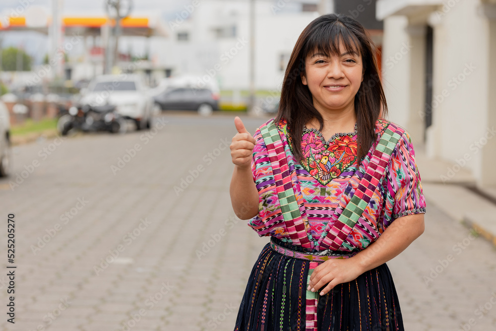 Fototapeta premium Young woman with her typical costume smiling with thumb up-Young happy hispanic woman in her city in Latin America-Latin woman with typical costume