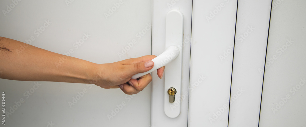 Woman hand opening the white plastic door Woman hand opening the white plastic door