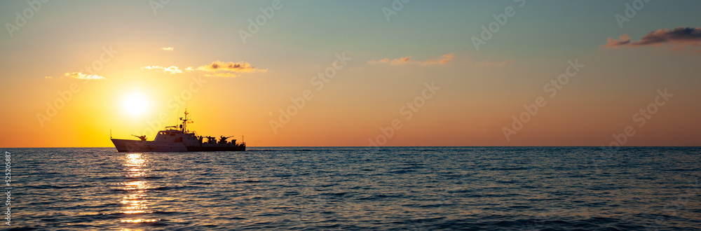 A ship at sunset on the sea horizon