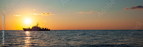 A ship at sunset on the sea horizon © ARAMYAN