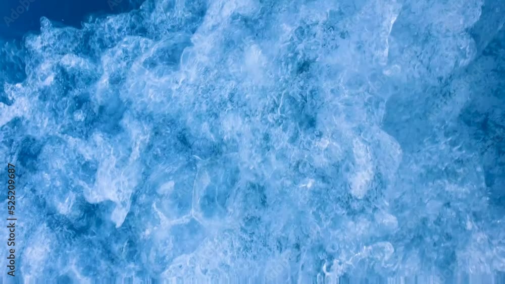 Hectic, chaotic whitewash ocean wake and spray from a fast moving motorboat, closeup of sea and fast flowing swirling  water