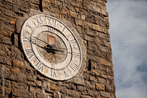 Selective blur on the vintage stone ancient clock of the clocktower of the parish church of saint george, or zupnjiska cerkev svetog jurija, a major landmark of the slovenian istria, in Piran photo