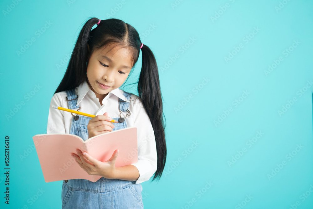 Smiling little girl in glasses and education concept holding text book, reading, thinking and writing. Smiling little girl in glasses and education concept holding text book, reading, thinking and writing.