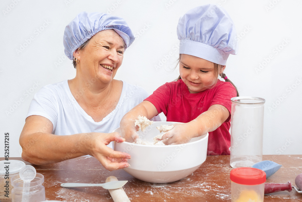 Grandmother and granddaughter make dough Grandmother and granddaughter make dough