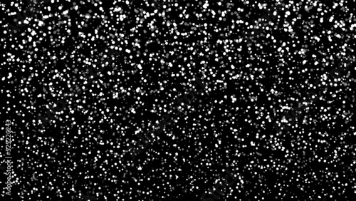 Snowfall bokeh on black background. Many snowflakes in flying in the air. Winte night  snowfall and blizzard  of snow at. Blur bokeh light effect creative background.