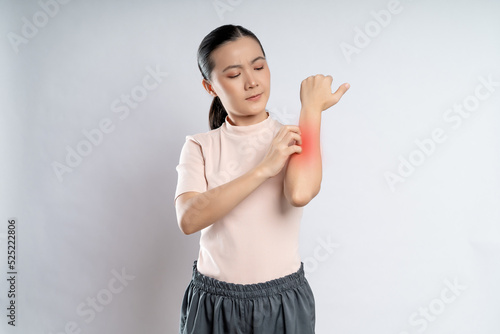 Fotografi Asian woman was sick with irritate itching her skin with red spot standing isolated on white background