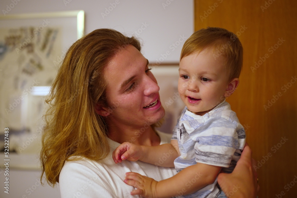 Handsome young man holding his little nephew Handsome young man holding his little nephew
