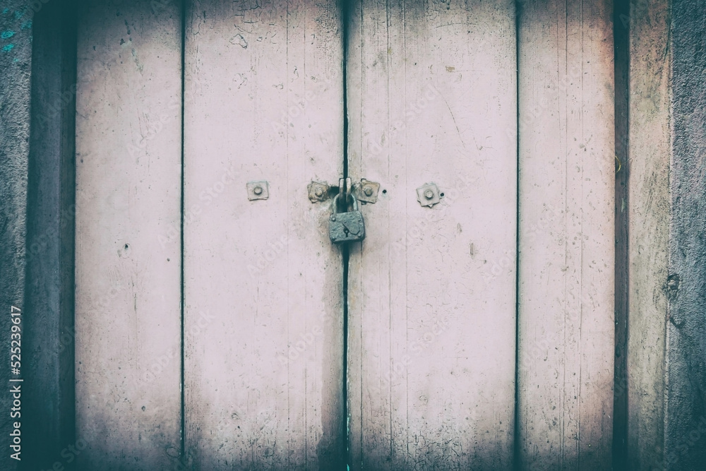 Padlock on painted dirty pink old wooden door, vintage background and texture Padlock on painted dirty pink old wooden door, vintage background and texture