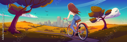 Girl rides on bike on road to city. Autumn landscape with fields, trees with orange leaves, girl on bicycle on path and town buildings on horizon, vector cartoon illustration