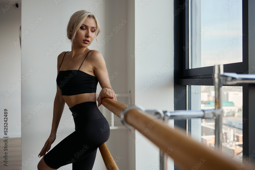 A beautiful girl is engaged in choreography. Doing a warm-up in a black tight-fitting suit. Dancing at the ballet barre A beautiful girl is engaged in choreography. Doing a warm-up in a black tight-fitting suit. Dancing at the ballet barre