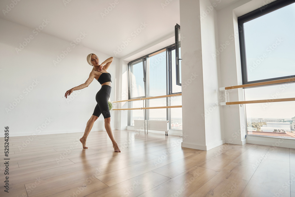 A beautiful girl is engaged in choreography. Doing a warm-up in a black tight-fitting suit. Dancing at the ballet barre A beautiful girl is engaged in choreography. Doing a warm-up in a black tight-fitting suit. Dancing at the ballet barre