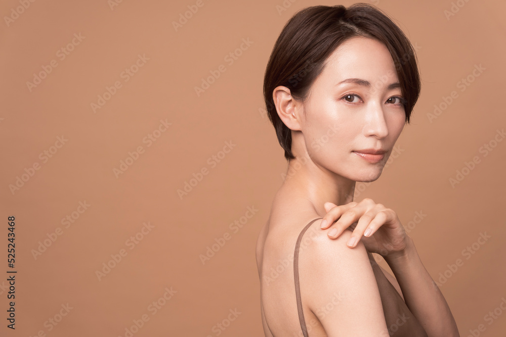 Obraz premium 美しいアジア人女性のビューティーイメージ。彼女は背中の見えるドレスを着ている。