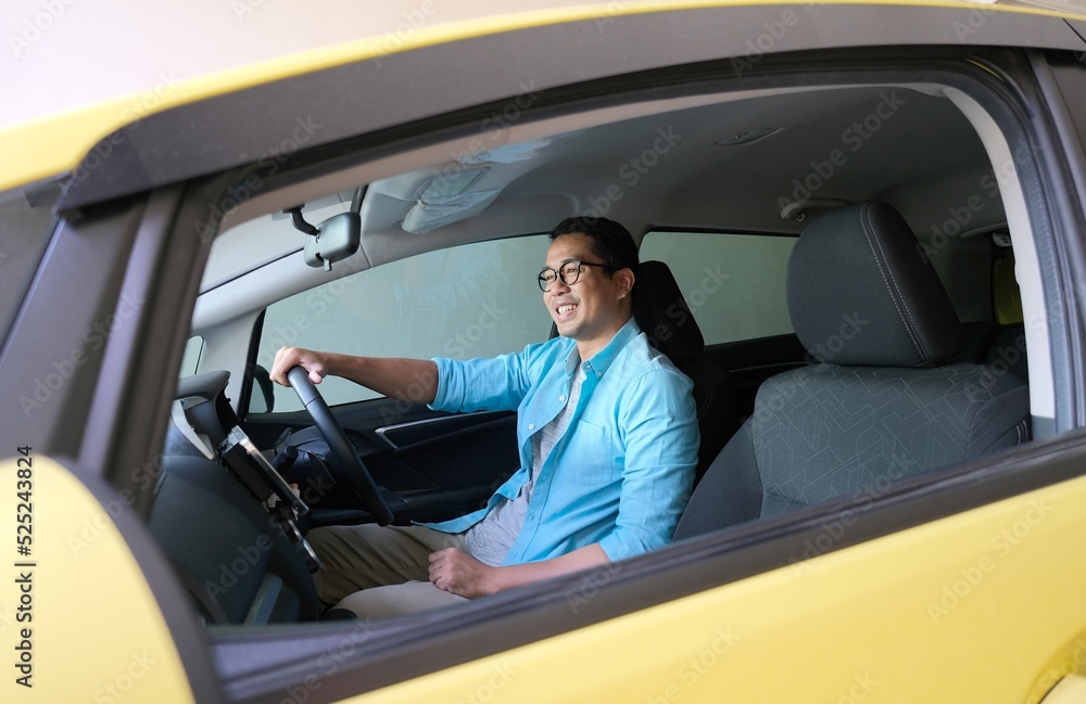 Asian man smiling happy while driving his car Asian man smiling happy while driving his car