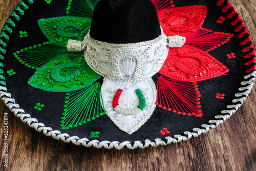 Mexican charro hat on wooden table. Typical mexican hat with the colors of the mexican flag. photo