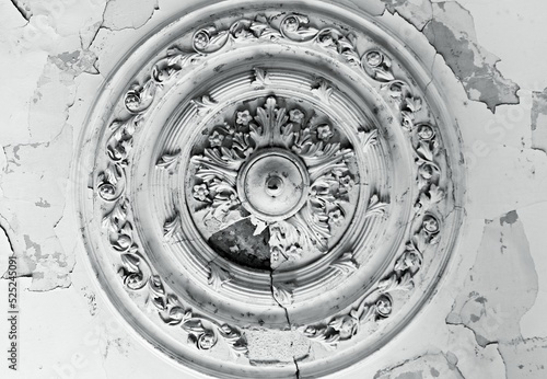 The old ceiling with crumbling plaster is decorated with stucco elements in the Baroque style - rosettes  volutes  floral ornaments.
