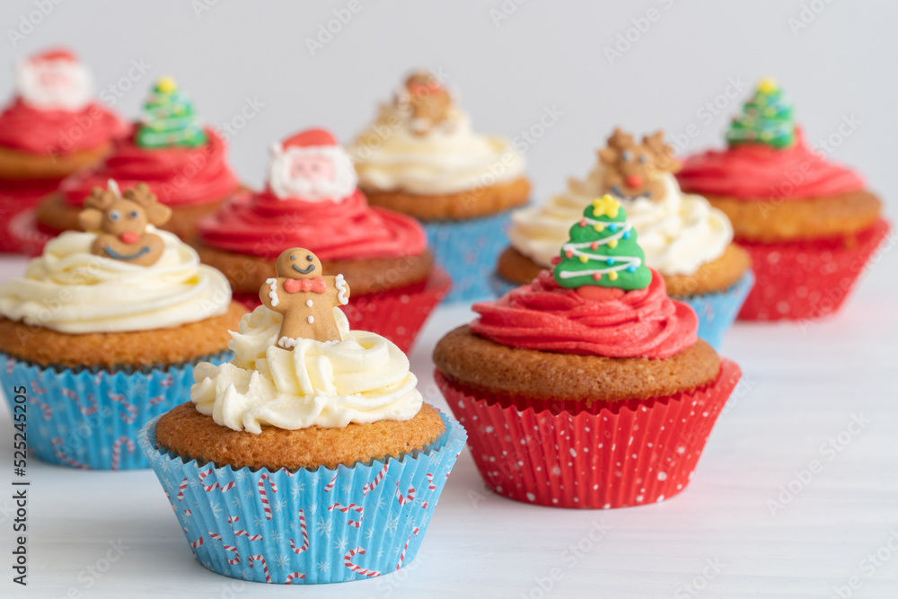 Close-Up of Assortment of Christmas Cupcakes on Table, Selective Focus with White Background Close-Up of Assortment of Christmas Cupcakes on Table, Selective Focus with White Background
