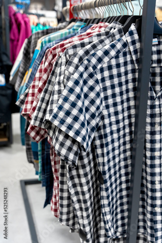 new plaid shirts with short sleeves on a hanger in a clothing store