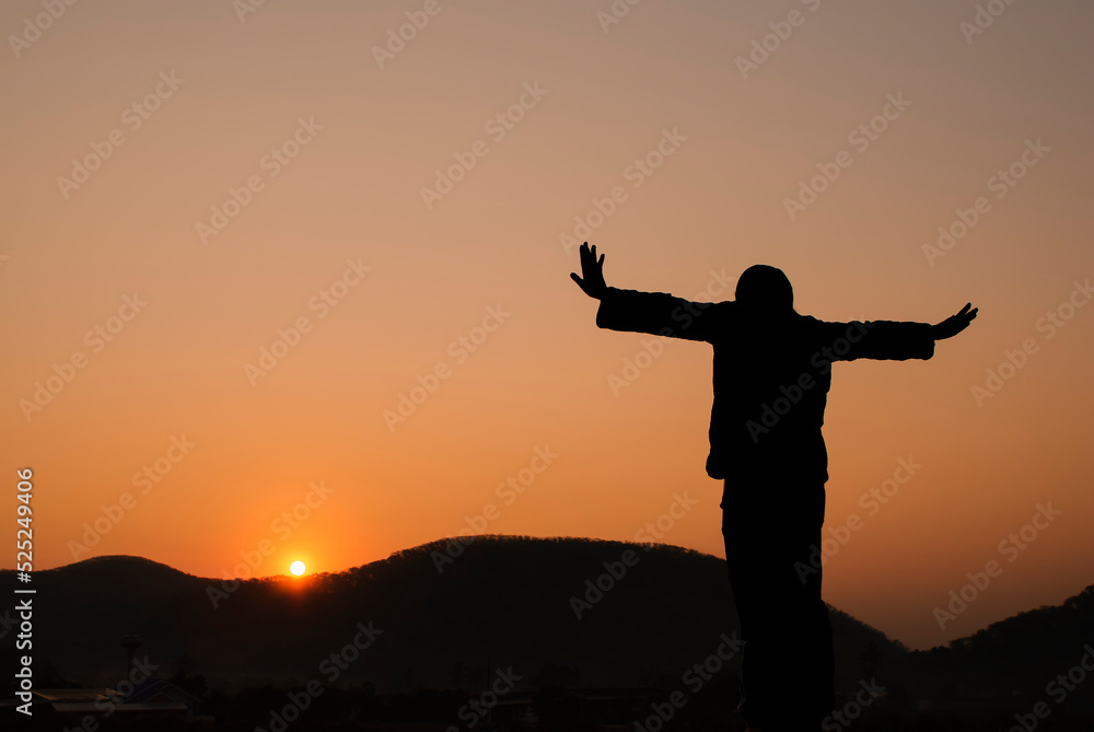 Freedom and International Day of Peace Concept. silhouette of a young woman standing with her arms free, calm in the sky at the peaceful morning sunrise, flying freely.