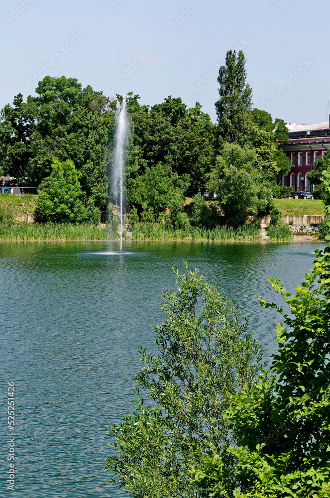 Φωτογραφία Spring panorama of a part of a residential area with a lake and a fountain,  Dru