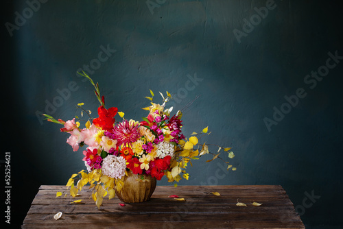 Foto autumn bouquet with red and yellow flowers in ceramic vase on dark background
